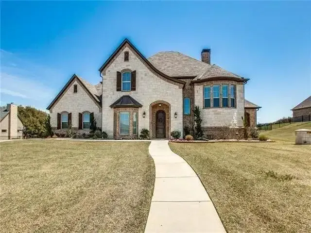 Custom limestone home with an arched entry and gabled roofline